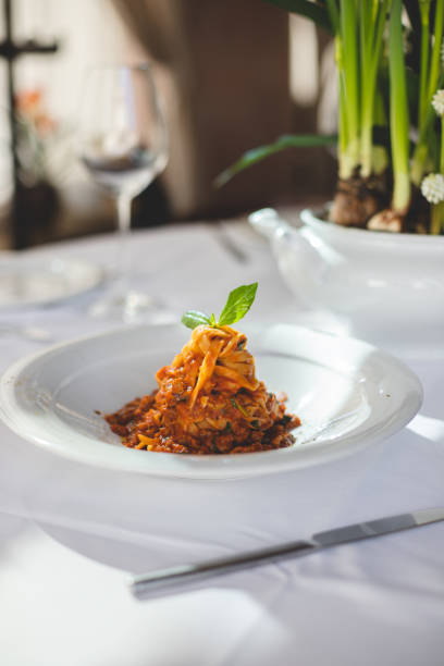 Traditional Italian pasta with tomatoes, basil and parmesan. Restaurant table setting.