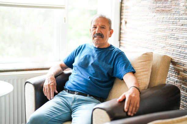istock senior man sitting on sofa at his home 1548049273