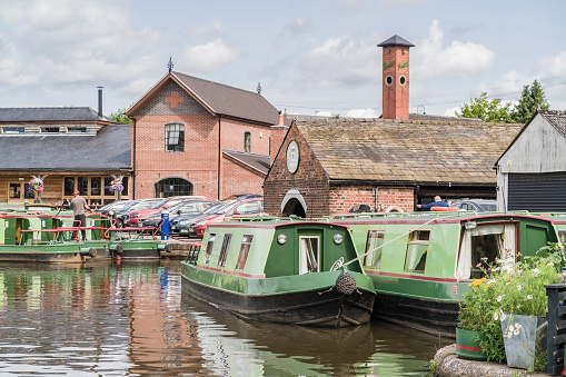 Stone, Staffordshire, England, July 13th 2023. View the canal with traditional narrowboat, transport, travel and tourism editorial illustration.