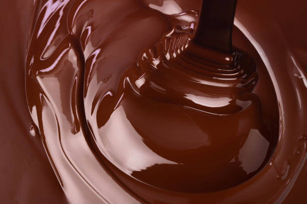 istock swirl melt dark chocolate background, sweet liquid cocoa dessert 1548055472