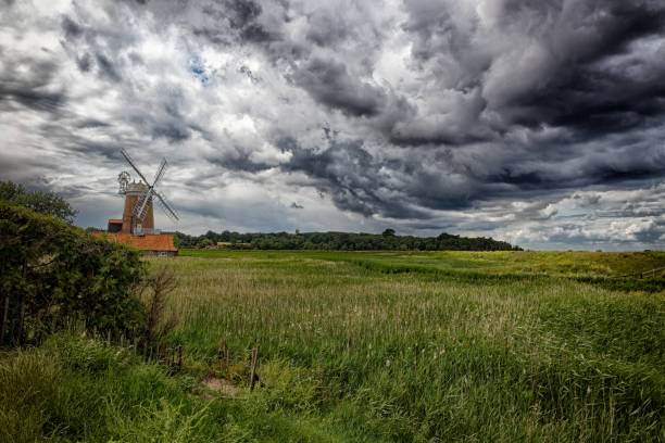 Dramatic storm clouds form over Cley mill at Cley next the sea in the county of Norfolk England