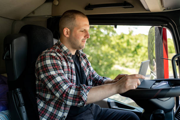 istock Transport truck driver sitting inside the cabin and using tablet 1548136878