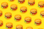 Seamless pattern burgers isolated on a yellow background