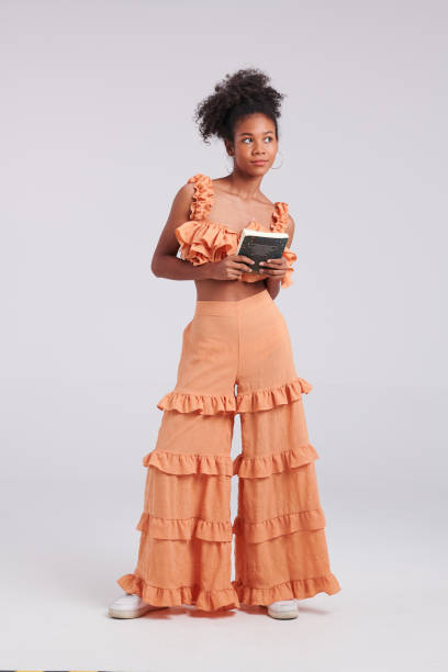istock Words & Wardrobe: Black Girl in Orange Shirt's Stunning Studio Pose 1548163154