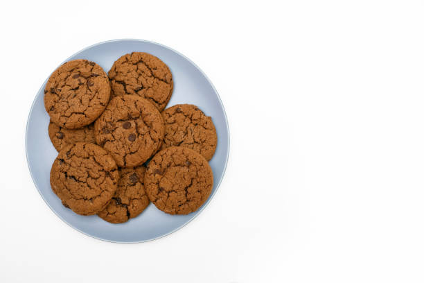 istock Cookies with chocolate chips lie on a plate on a white background 1548228634