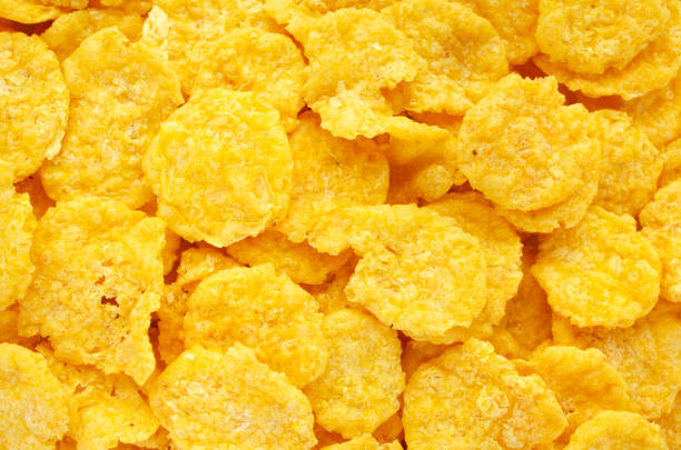 Yellow corn flakes background, texture, top view. Corn flakes for morning breakfast, background, texture, top view. Background and texture of yellow corn flakes, top view