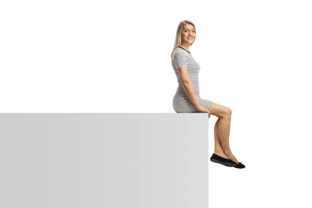 istock Casual young woman sitting on a white wall 1548239185