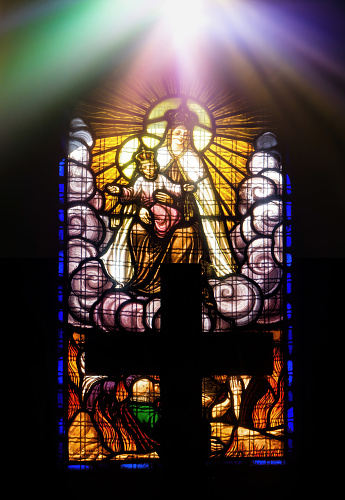 Mahébourg, Grand Port District, Mauritius: Notre Dame Des Anges, backlit triple stained glass window displaying Jesus on the cross and the Virgin Mary.