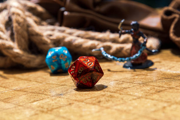 istock Red d20 on a battle grid, with gaming mini, rope, and coin bag 1548267920