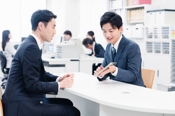 istock Male staff using a tablet to guide customers at the counter 1548285065