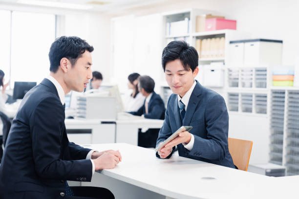 istock Male staff using a tablet to guide customers at the counter 1548285542