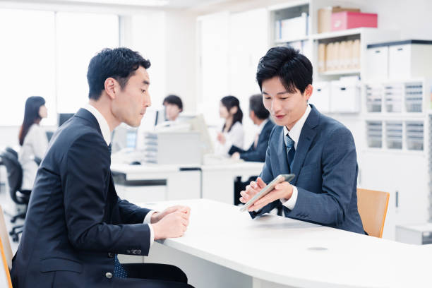 istock Male staff using a tablet to guide customers at the counter 1548285585