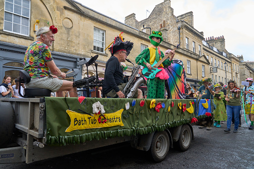 Bath, England, United Kingdom - 8 July 2023: Music and dance group parade in ornate costumes performing at the annual carnival as it progresses through the streets of the historic city of Bath in Somerset.