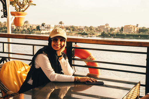 portrait of happy woman who travels on a boat during sunset on nile river, Cairo
