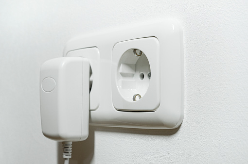 Central European double socket with charger plugged in - symbol for power consumption.