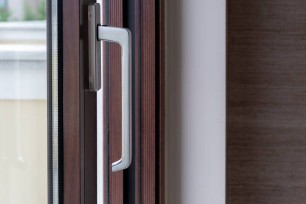 istock Aluminum silver handle on close window, door against brown frame background. Energy efficient. 1548356359
