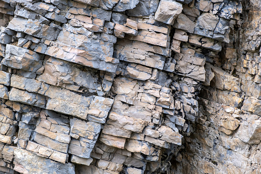 Layered empty rock, limestone, sandstone, slate formation background, texture. Natural geological stratified rough surface. Copy space