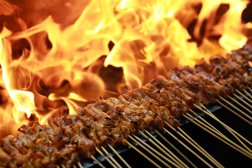 At a bustling street food market in Malaysia, sizzling satay is a captivating sight. The fragrant aroma of the skewered and grilled meat fills the air, enticing locals and tourists alike.