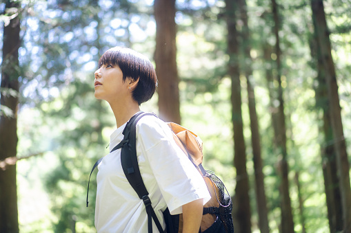 An  Asian woman is  hiking in the mountains of Japan.