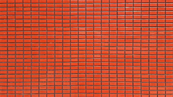 close up terra cotta colored mosaic wall tiles. ceramic tiles in rectangle pattern, orange color. vintage red mosaic kitchen wall pattern used as background.