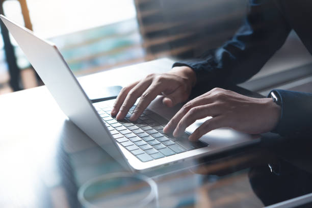 istock Business man hands typing on laptop computer keyboard, searching information, surfing the internet on dark office desk, distance job, online working, business and technology concept 1548490961
