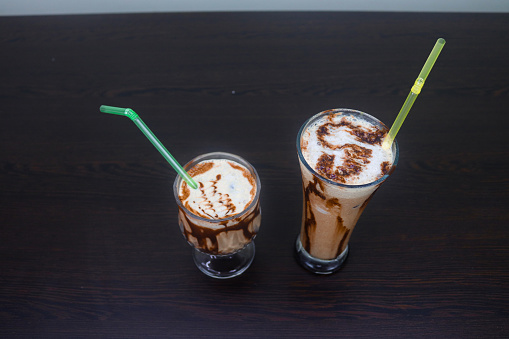 The cold coffee is light brown in color and is filled with ice cubes. The image is refreshing and inviting, and will surely appeal to those looking for a cool and refreshing drink on a hot day.