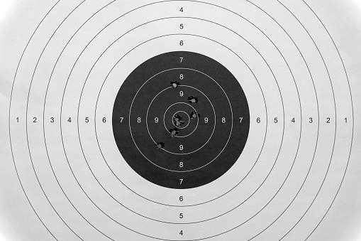 Paper target with bullet holes, close-up photo