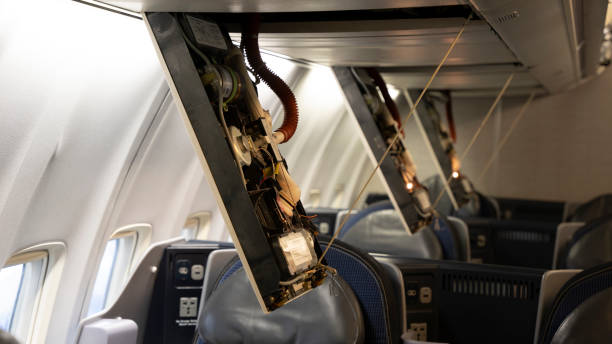 Passenger service panels dropped for maintenance in the interior of a 757 commercial Passenger airplane. Passenger service panels dropped for maintenance in the interior of a 757 commercial Passenger airplane. oxygen mask plane stock pictures, royalty-free photos & images