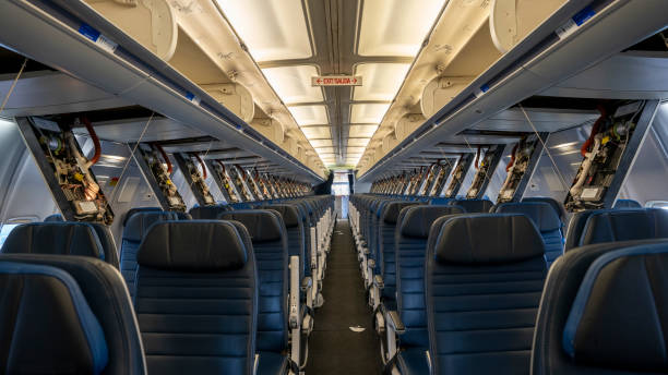Passenger service panels dropped for maintenance in the interior of a 757 commercial Passenger airplane. Passenger service panels dropped for maintenance in the interior of a 757 commercial Passenger airplane. oxygen mask plane stock pictures, royalty-free photos & images