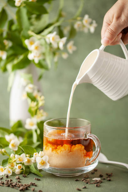 istock Composition with cup of jasmine milk tea and flowers on green background 1548592049