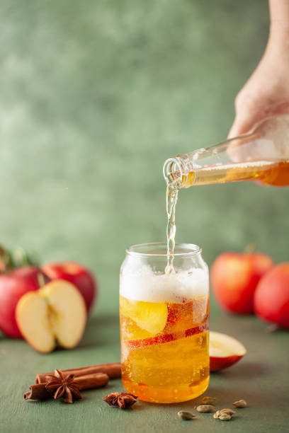 boozy refresing cold hard apple cider en un vaso de pinta y botella sobre mesa de madera. espacio de copia - cider fotografías e imágenes de stock