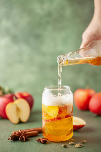 木のテーブルの上のパイントグラスとボトルに冷たい硬いアップルサイダーをリフレージングする大酒飲み。スペースをコピーする - beer beer glass drink alcohol ストックフォトと画像