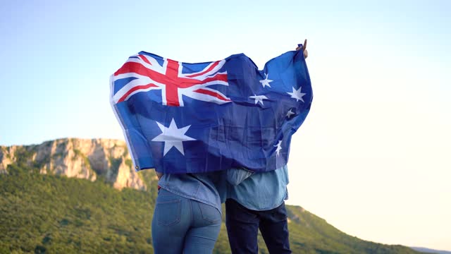 Couple holding a Australian flag at the top of the mountain