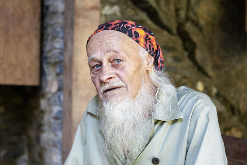 Portrait of the cave keeper - an old man with a gray beard and clear eyes, the concept of active longevity. High quality photo