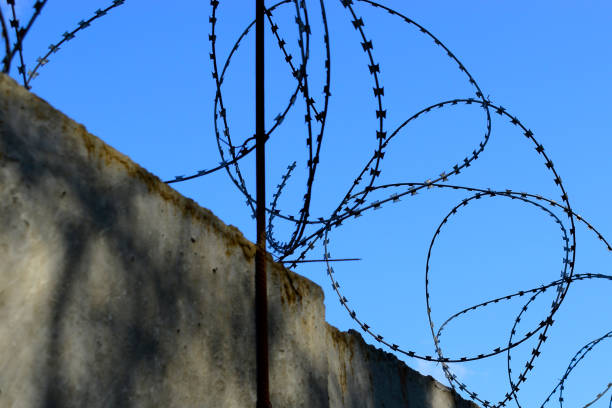 istock barbed wire on a concrete fence. concept prison, border, penetration, protection. 1548646922