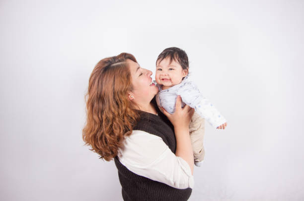 istock loving mom with baby on light photo studio 1548665627