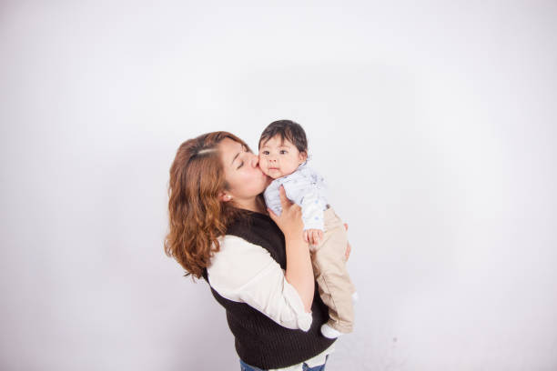 istock loving mom with baby on light photo studio 1548665644
