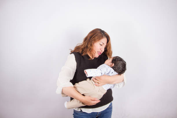 istock loving mom with baby on light photo studio 1548666179