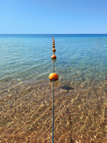Close up of Line of yellow buoys floating in the water of the Red Sea. Beaconing and aquatic signage.
