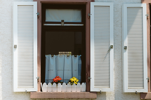 open old wooden shutters on a house with flower box