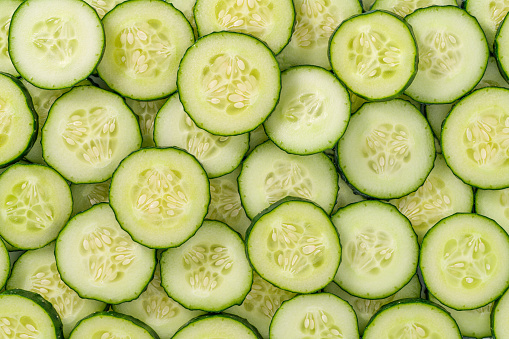 Cucumber slices arrangement in a row composition full frame background summer vegetables