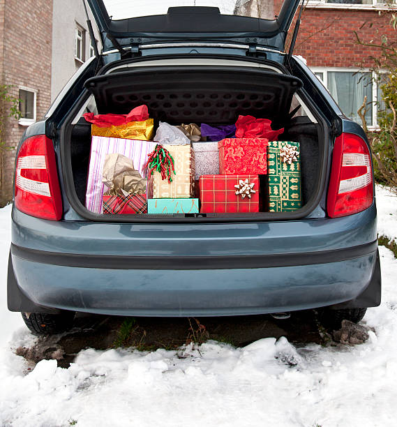 Car boot, filled with Christmas presents, snow underfoot stock photo