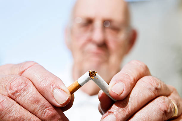 non è mai troppo tardi per smettere di fumare. uomo anziano rottura sigaretta - patriarchy foto e immagini stock