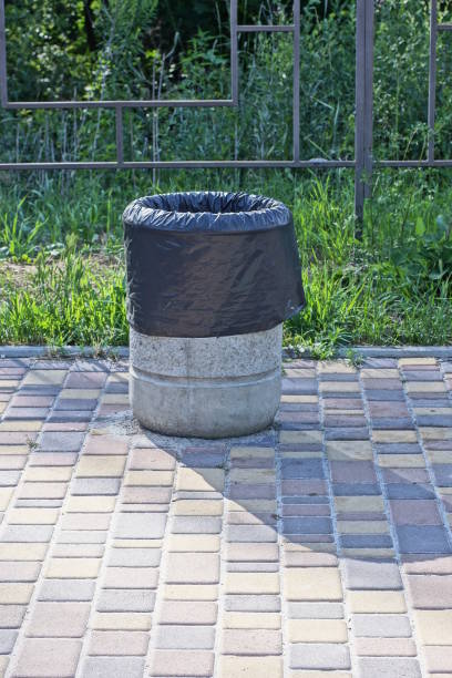 istock one gray concrete urn with a black bag stands on a brown sidewalk 1548839468