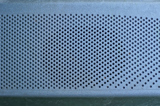 gray texture of a plastic grill over a speaker on an old TV