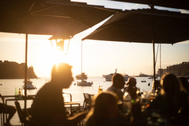 istock people dining at seaside restaurant with romantic sunset 1548857406