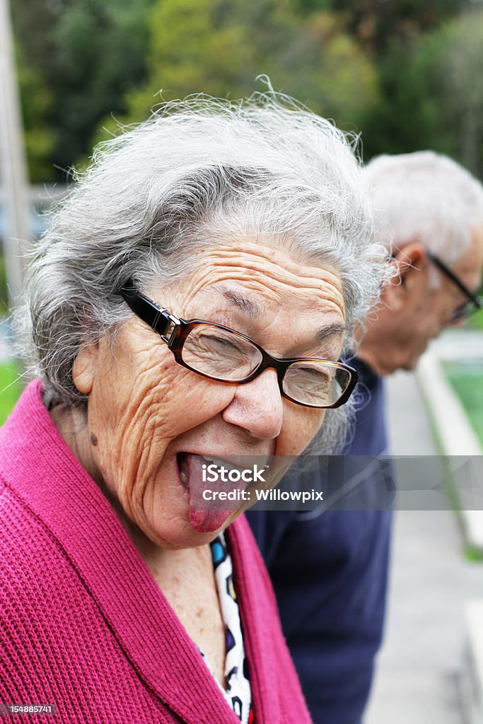 Senior femme drôle de tête en restant sur la languette - Photo de Femmes libre de droits