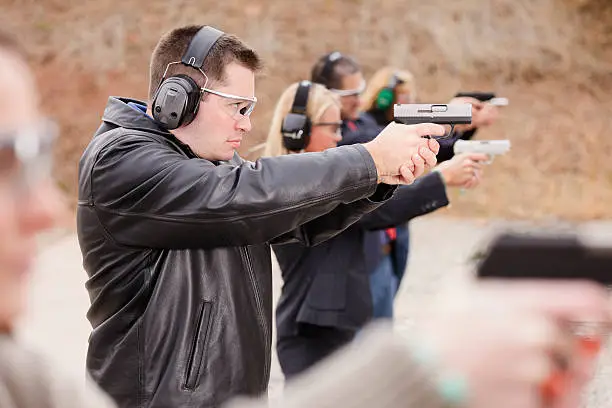 A group of people practicing at the gun range. Photographed on location at a shooting range.