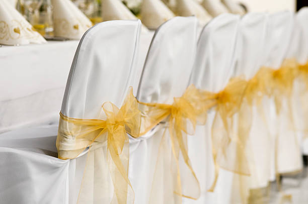 istock White wedding chairs with golden ribbon 154885819