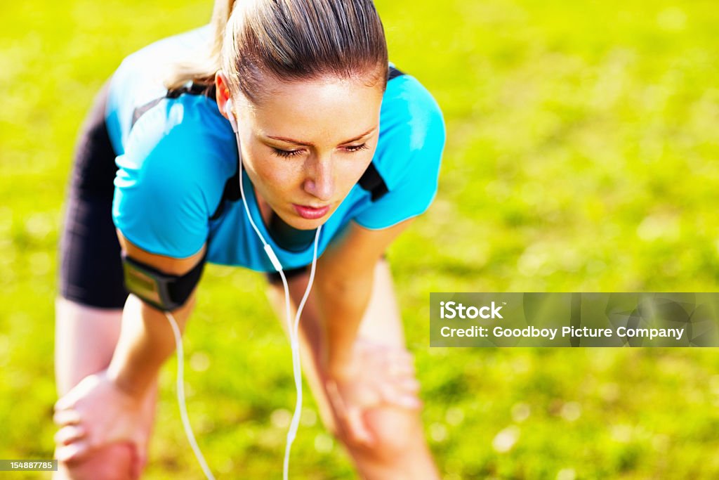 Esausta dopo una donna jogging nel parco - Foto stock royalty-free di Abbigliamento sportivo